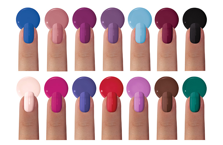 Foto de dedos mostrando diferentes esmaltes de uñas sobre fondo blanco. Catorce uñas exhiben diversos colores como azul, rosa, púrpura, rojo, negro y verde. Cada dedo muestra la aplicación del esmalte y una gota del color correspondiente.